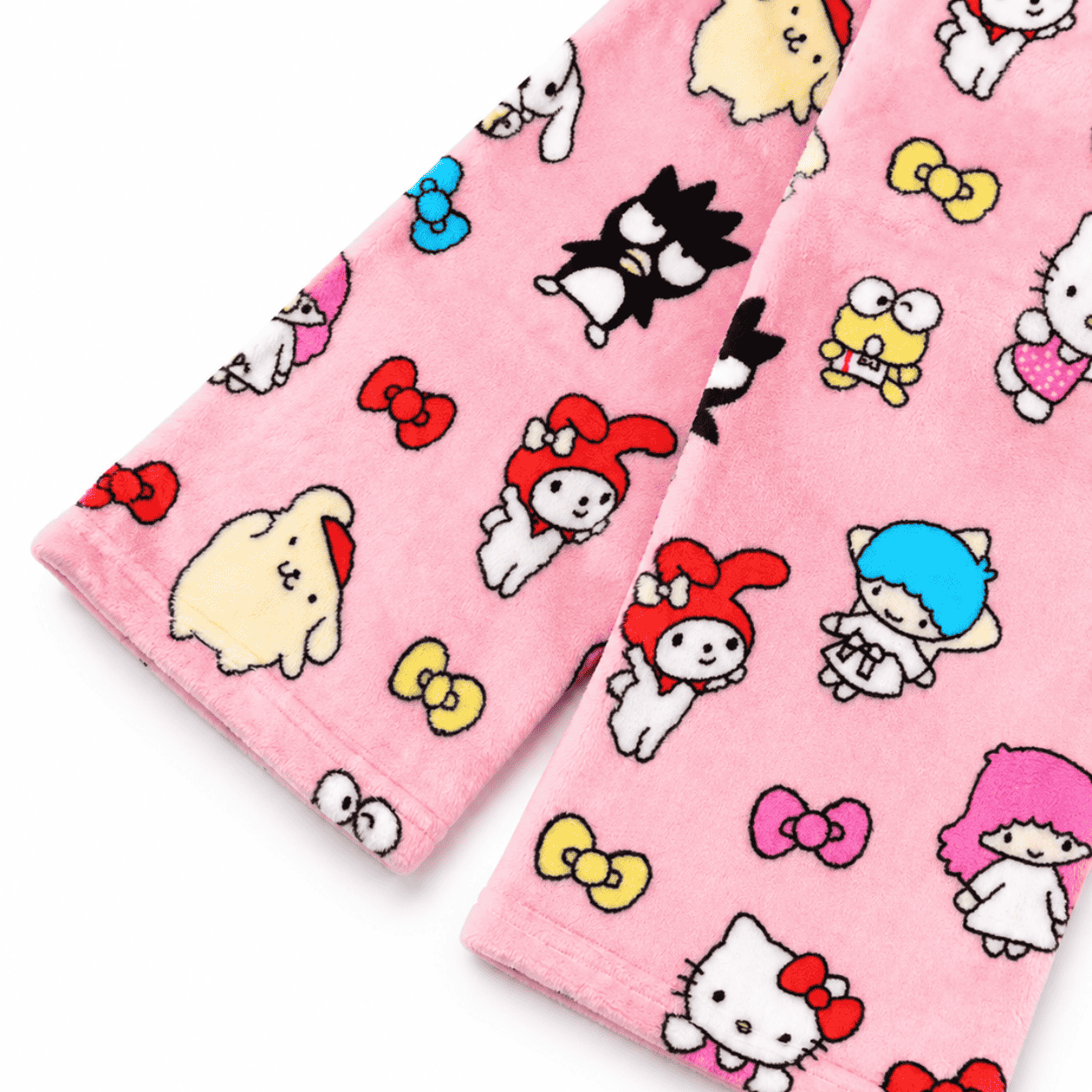 Pink pajama pants leg close-up showing scattered character faces and bows pattern