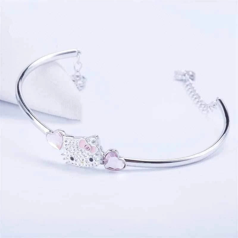 Silver cuff bracelet with Hello Kitty face charm and pink heart dangle accents