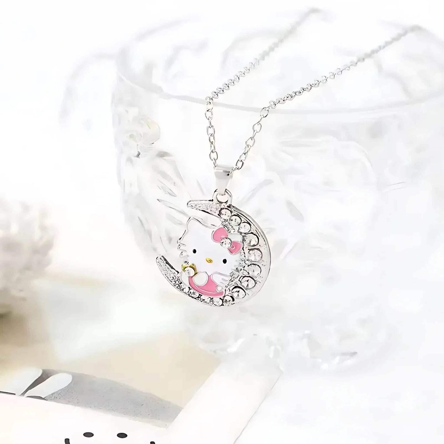 Silver moon pendant necklace with Hello Kitty face and pink bow, rhinestone-edged charm