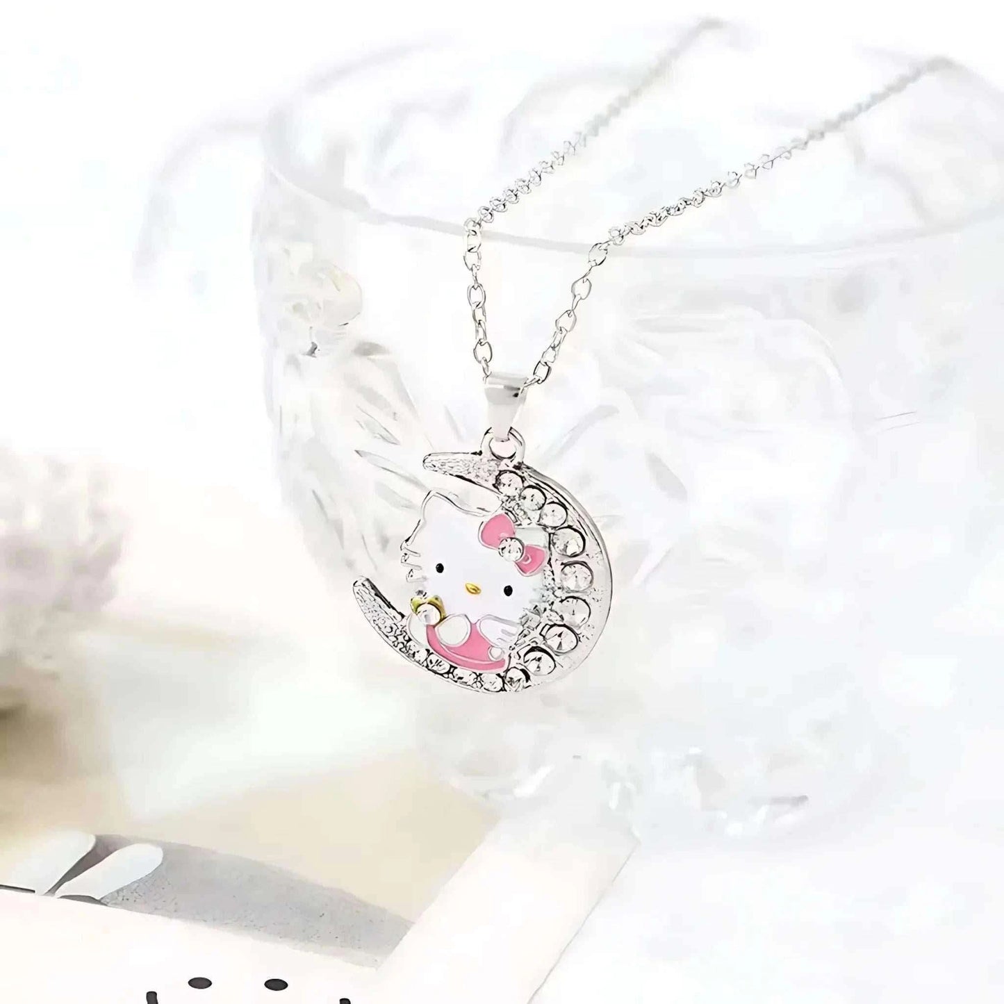 Silver moon pendant necklace with Hello Kitty face, pink accents, and rhinestone trim