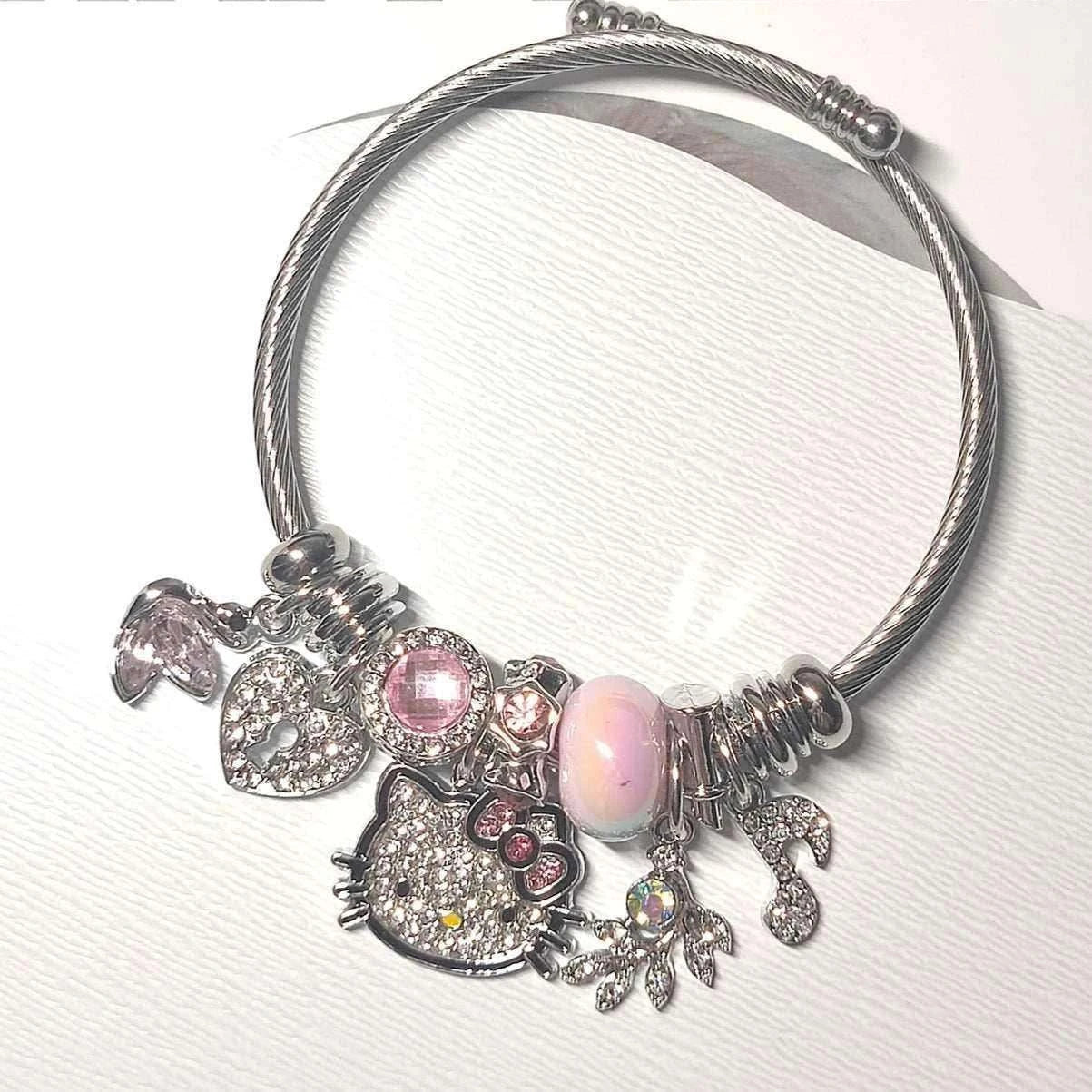Silver charm bracelet with Hello Kitty face, pink opal bead, hearts, and star charms