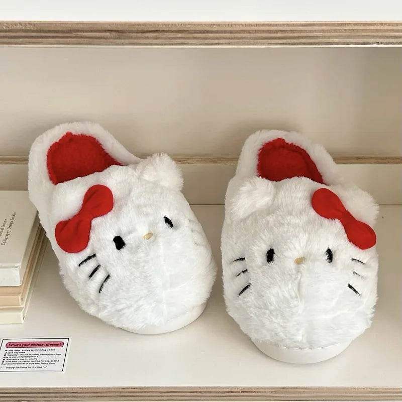 White Hello Kitty plush slippers on a ledge; red interiors and red bow accents