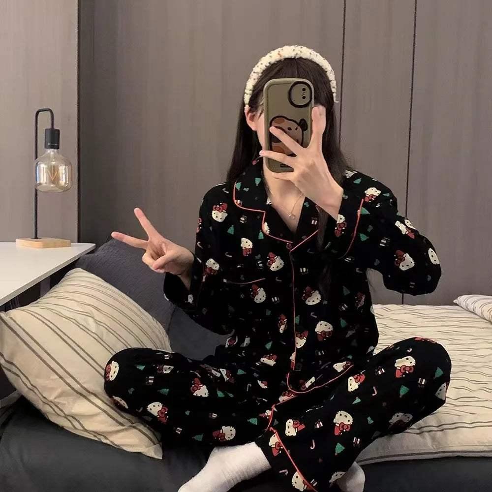 Model wearing black Hello Kitty Christmas pajama set with button-front top and matching bottoms