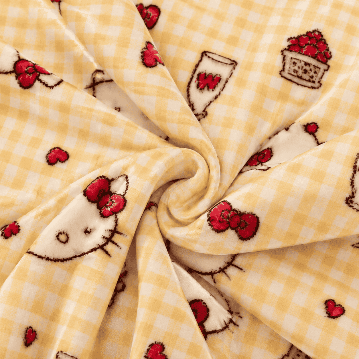 Close-up of yellow gingham fabric with Hello Kitty faces and bows