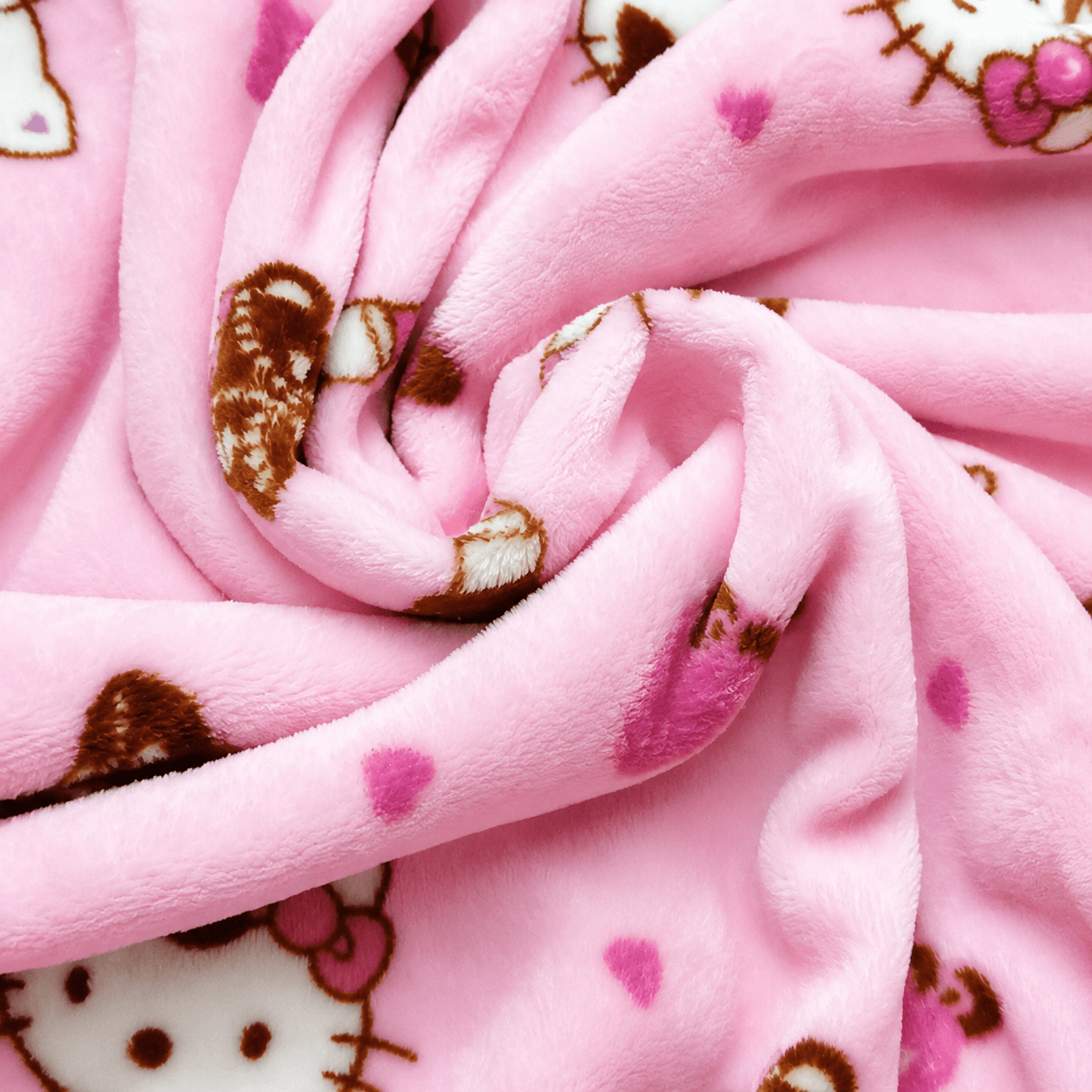 Pink plush pajama pants fabric closeup with Hello Kitty icons and hearts
