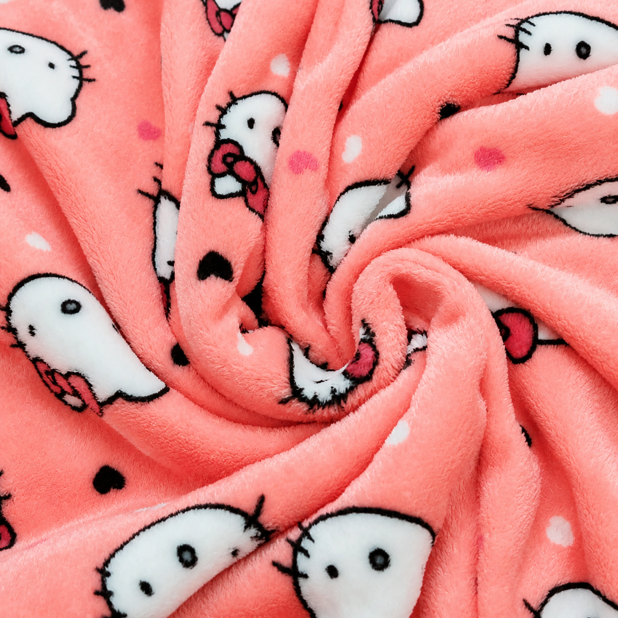 Pink fleece pajama pants fabric close-up with Hello Kitty and hearts