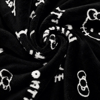 Black plush pajama fabric with white Hello Kitty icons and script print