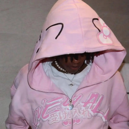 Light pink Hello Kitty zip-up hoodie with cat face hood and heart zipper charm.