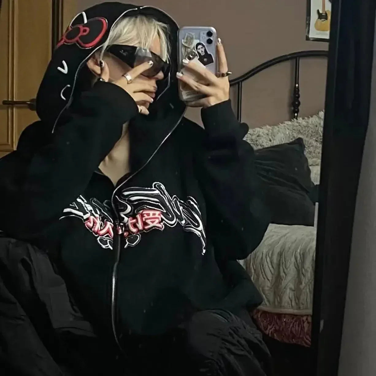 Black Hello Kitty zip-up hoodie with red bow cat face on hood; front zipper and logo.