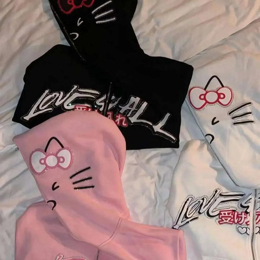 Black zip-up hoodie with Hello Kitty-style cat face and bow, graphic logo on chest
