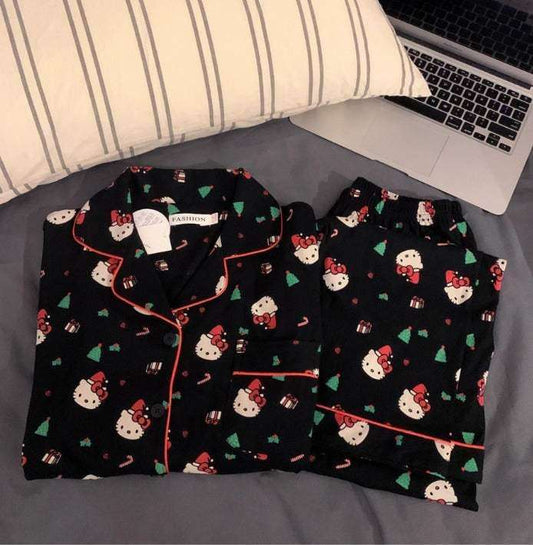 Hello Kitty Christmas pajama set flat lay: black top and shorts with red piping, allover print